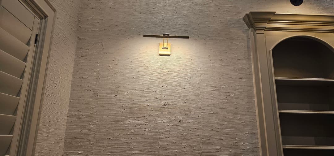 Modern interior wall with textured finish and stylish wall sconce lighting.